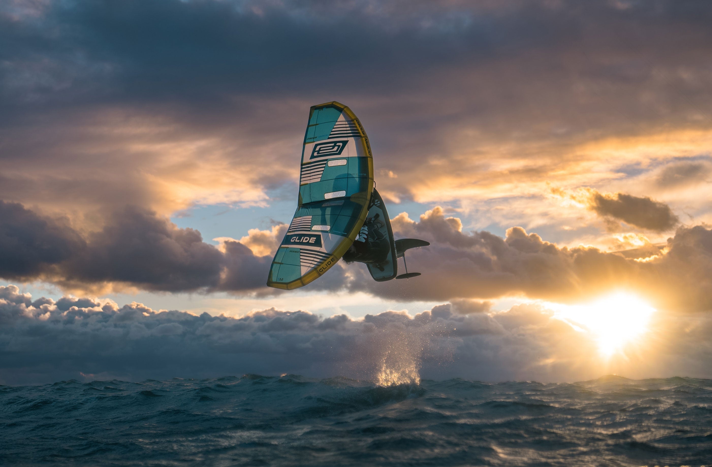Mathis Ghio using the Ocean Rodeo Glide A-Series Wing in front of a moody sunset